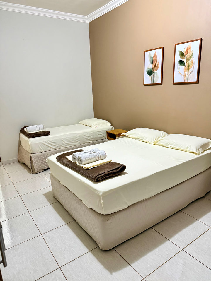 Cama de casal e cama de solteiro com criados-mudos de madeira
