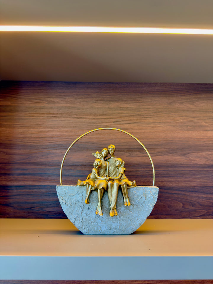 Escultura dourada de um casal, sobre a estante